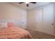 Cozy bedroom features plush carpet, a ceiling fan, a closet and a neatly made bed with accent pillows at 550 W Powell Way, Chandler, AZ 85248