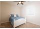 Cozy bedroom features plush carpet, a ceiling fan, and a sunny window with plantation shutters and a white wood bed at 550 W Powell Way, Chandler, AZ 85248