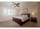 This bedroom boasts a ceiling fan, neutral paint, carpeted floor, and a large window with shutters at 550 W Powell Way, Chandler, AZ 85248