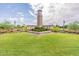 Well-maintained community clock tower set amidst a green lawn and colorful flowerbeds, creating a focal point at 550 W Powell Way, Chandler, AZ 85248