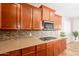 Kitchen featuring wood cabinets, mosaic tile backsplash, stainless appliances, and gas cooktop at 550 W Powell Way, Chandler, AZ 85248