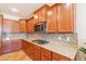 Kitchen featuring wood cabinets, mosaic tile backsplash, stainless appliances, and gas cooktop at 550 W Powell Way, Chandler, AZ 85248