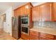 Kitchen featuring stainless steel appliances, granite countertops, and wood cabinets at 550 W Powell Way, Chandler, AZ 85248