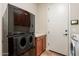 Laundry area with full-size stacked washer/dryer and cabinets providing storage convenience at 550 W Powell Way, Chandler, AZ 85248