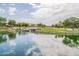 Tranquil community pond with a small waterfall, green lawn, and surrounding houses, offering a peaceful retreat at 550 W Powell Way, Chandler, AZ 85248