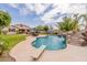 Lush backyard with a sparkling pool, rock slide, diving board, and outdoor dining area for summer fun at 550 W Powell Way, Chandler, AZ 85248