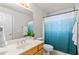 Bright bathroom featuring an undermount sink with a wooden vanity and a shower with a blue patterned curtain at 6002 N 5Th Pl, Phoenix, AZ 85012