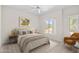 Bright bedroom with a view to the outdoors, neutral tones, a cozy chair and a modern bed frame at 6002 N 5Th Pl, Phoenix, AZ 85012