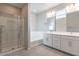 Modern bathroom with a glass-enclosed shower, soaking tub, double vanity, and tile floors at 613 W Winchester Dr, Chandler, AZ 85286