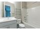 Bright bathroom features a shower-tub combo, glass shelves, and white vanity at 613 W Winchester Dr, Chandler, AZ 85286