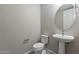Half-bathroom featuring pedestal sink, tiled floor, and modern toilet at 613 W Winchester Dr, Chandler, AZ 85286