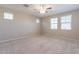 Bright bedroom with neutral carpet, multiple windows, and ceiling fan at 613 W Winchester Dr, Chandler, AZ 85286