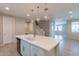 A kitchen island with white cabinets, modern sink and faucet, with a view of the staircase and living space at 613 W Winchester Dr, Chandler, AZ 85286