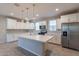 A modern kitchen features white cabinets, stainless steel appliances, a large island, and modern backsplash at 613 W Winchester Dr, Chandler, AZ 85286