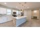 A gourmet kitchen features white cabinets, stainless steel appliances, a large island, and modern backsplash at 613 W Winchester Dr, Chandler, AZ 85286