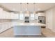 A gourmet kitchen with white cabinets, a large island, stainless steel appliances, and modern backsplash at 613 W Winchester Dr, Chandler, AZ 85286
