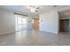 A well-lit living room with tile flooring, neutral walls, and sliding glass doors leading to the balcony at 613 W Winchester Dr, Chandler, AZ 85286