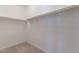 Empty walk-in closet features carpet floors and wooden shelving at 613 W Winchester Dr, Chandler, AZ 85286