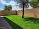 An expansive backyard featuring lush green grass, bordered by a privacy wall and brick pavers at 6620 W Shaw Butte Dr, Glendale, AZ 85304