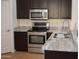 Kitchen features granite countertops, stainless appliances and dark wood cabinets at 6620 W Shaw Butte Dr, Glendale, AZ 85304