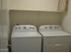 Convenient laundry room featuring a modern white washer and dryer, with practical shelving for supplies at 6620 W Shaw Butte Dr, Glendale, AZ 85304