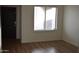 The living room has laminate flooring, a large window, and neutral paint colors at 6620 W Shaw Butte Dr, Glendale, AZ 85304