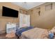 Cozy bedroom featuring warm tones, a TV, and stylish decor for a comfortable and inviting space at 6840 S Crystal Way, Chandler, AZ 85249