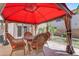 Cozy patio setup with round table and four wicker chairs under a large red umbrella at 6840 S Crystal Way, Chandler, AZ 85249
