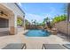 Beautiful backyard pool with stone waterfall feature, palm trees, and patio seating at 6840 S Crystal Way, Chandler, AZ 85249