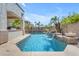 Beautiful backyard pool features rock waterfalls, palm trees, and a built-in BBQ area for entertaining at 6840 S Crystal Way, Chandler, AZ 85249