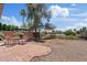 Large backyard featuring gravel and brick, with greenery visible in the background at 706 N El Dorado Dr, Gilbert, AZ 85233