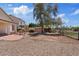 Spacious backyard with patio seating area, large tree and desert landscaping at 706 N El Dorado Dr, Gilbert, AZ 85233