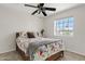 Cozy bedroom with floral bedding, ceiling fan, and a window offering natural light at 706 N El Dorado Dr, Gilbert, AZ 85233