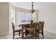 Bright dining area with a wooden table, six chairs, a modern light fixture, and wood-look flooring at 706 N El Dorado Dr, Gilbert, AZ 85233