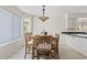 Bright dining area with a wooden table, six chairs, a modern light fixture, and wood-look flooring at 706 N El Dorado Dr, Gilbert, AZ 85233