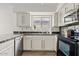 Well-lit kitchen featuring white cabinets, modern appliances, and tile flooring at 706 N El Dorado Dr, Gilbert, AZ 85233