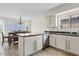 Bright kitchen featuring white cabinets, stone countertops, and stainless steel appliances, open to a dining area at 706 N El Dorado Dr, Gilbert, AZ 85233