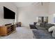 Bright and spacious living room featuring a plush gray sofa, high ceilings, media center, and neutral carpet at 706 N El Dorado Dr, Gilbert, AZ 85233
