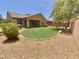 A well-kept backyard features a green lawn and desert landscaping at 7116 W Sophie Ln, Laveen, AZ 85339