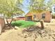 A well-kept backyard features a green lawn, desert landscaping, and trees at 7116 W Sophie Ln, Laveen, AZ 85339
