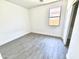 Clean bedroom with wood-look flooring, closet, and a bright window at 7116 W Sophie Ln, Laveen, AZ 85339