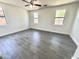 Spacious bedroom featuring sleek wood-look tile flooring and a modern ceiling fan at 7116 W Sophie Ln, Laveen, AZ 85339