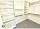 Walk-in closet with built-in shelving and wood-look tile flooring at 7116 W Sophie Ln, Laveen, AZ 85339