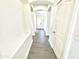 Clean hallway featuring tile floors, and white walls, leading to the front door at 7116 W Sophie Ln, Laveen, AZ 85339