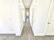 Clean hallway with ceramic tile flooring connects the living spaces and bedrooms in the home at 7116 W Sophie Ln, Laveen, AZ 85339
