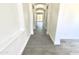 Bright hallway featuring tile floors and white walls, creating a seamless transition between living spaces at 7116 W Sophie Ln, Laveen, AZ 85339