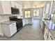 Well-lit kitchen features a breakfast bar, white cabinets, and gray countertops with a tiled backsplash at 7116 W Sophie Ln, Laveen, AZ 85339