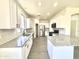 Modern kitchen with stainless steel appliances, granite countertops, and white cabinets offers a clean, stylish design at 7116 W Sophie Ln, Laveen, AZ 85339