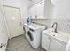 This laundry room includes storage cabinets, sink, and machines at 7116 W Sophie Ln, Laveen, AZ 85339