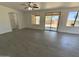 Large, open living room features tile floors, modern ceiling fan, and a sliding glass door to backyard at 7116 W Sophie Ln, Laveen, AZ 85339